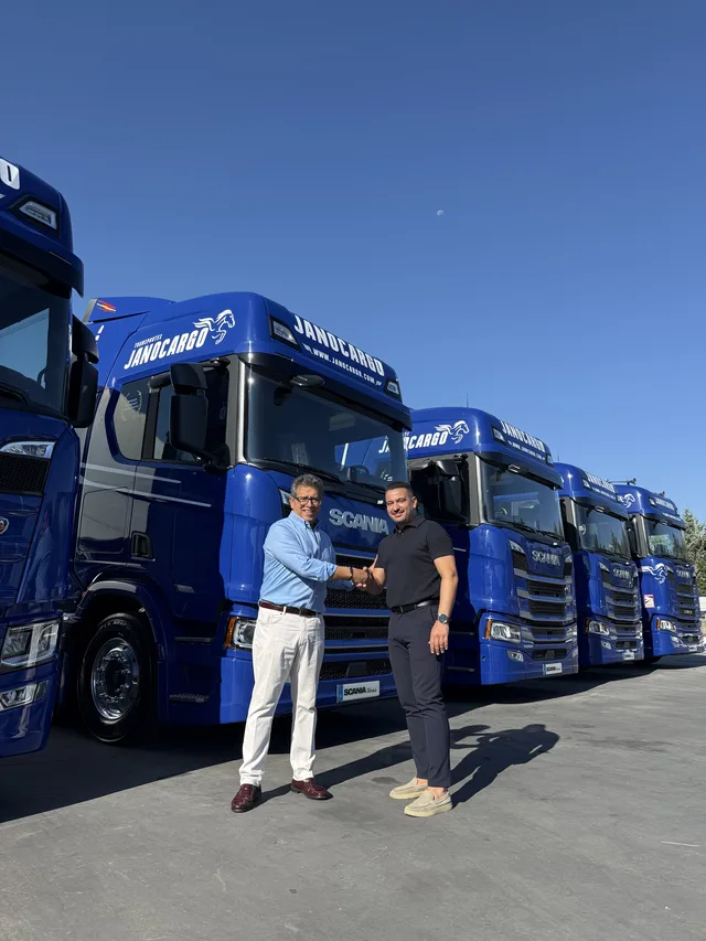 José Ramón Jano estrecha la mano a un representante de Scania junto a los nuevos camiones